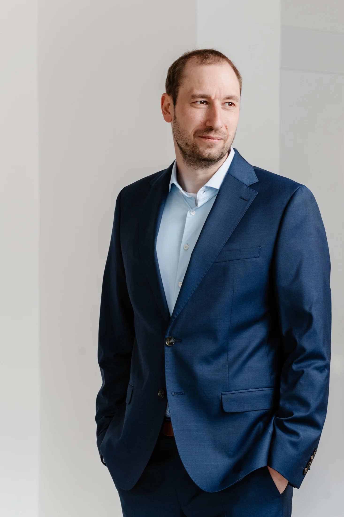 Martin Berdel standing in a blue suit