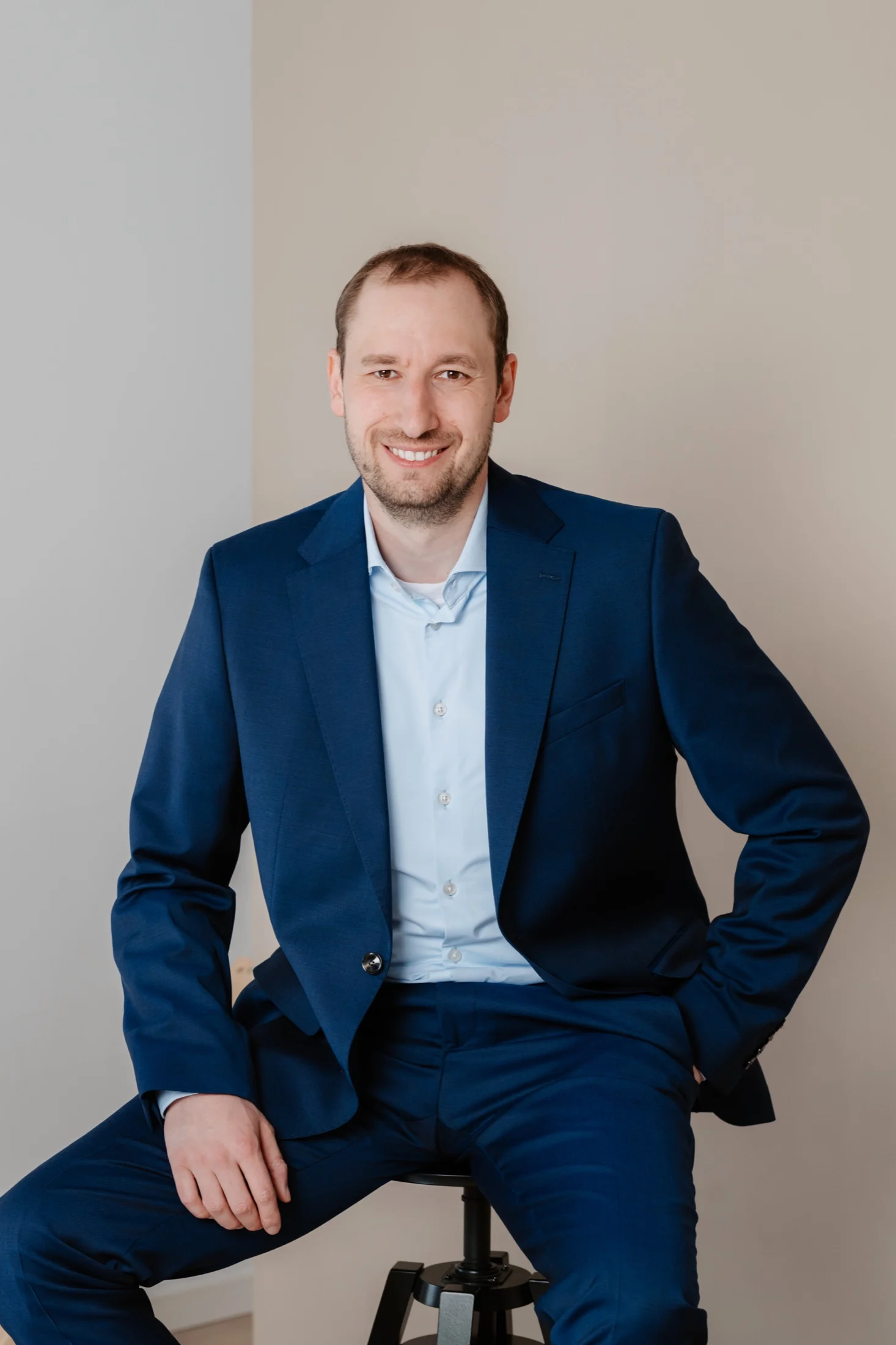 Martin Berdel seated in a relaxed executive portrait