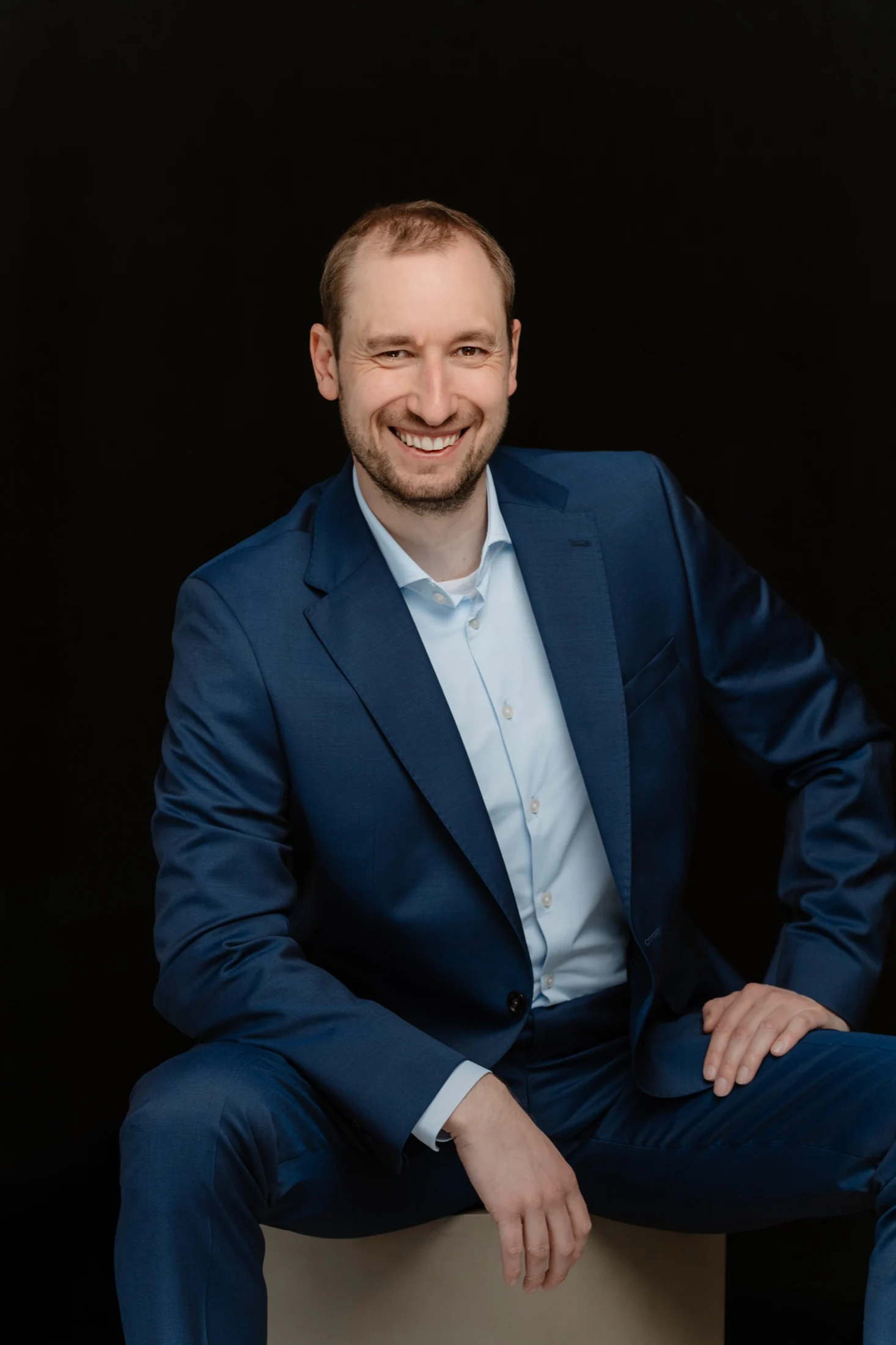 Martin Berdel in conversation, seated in a blue suit
