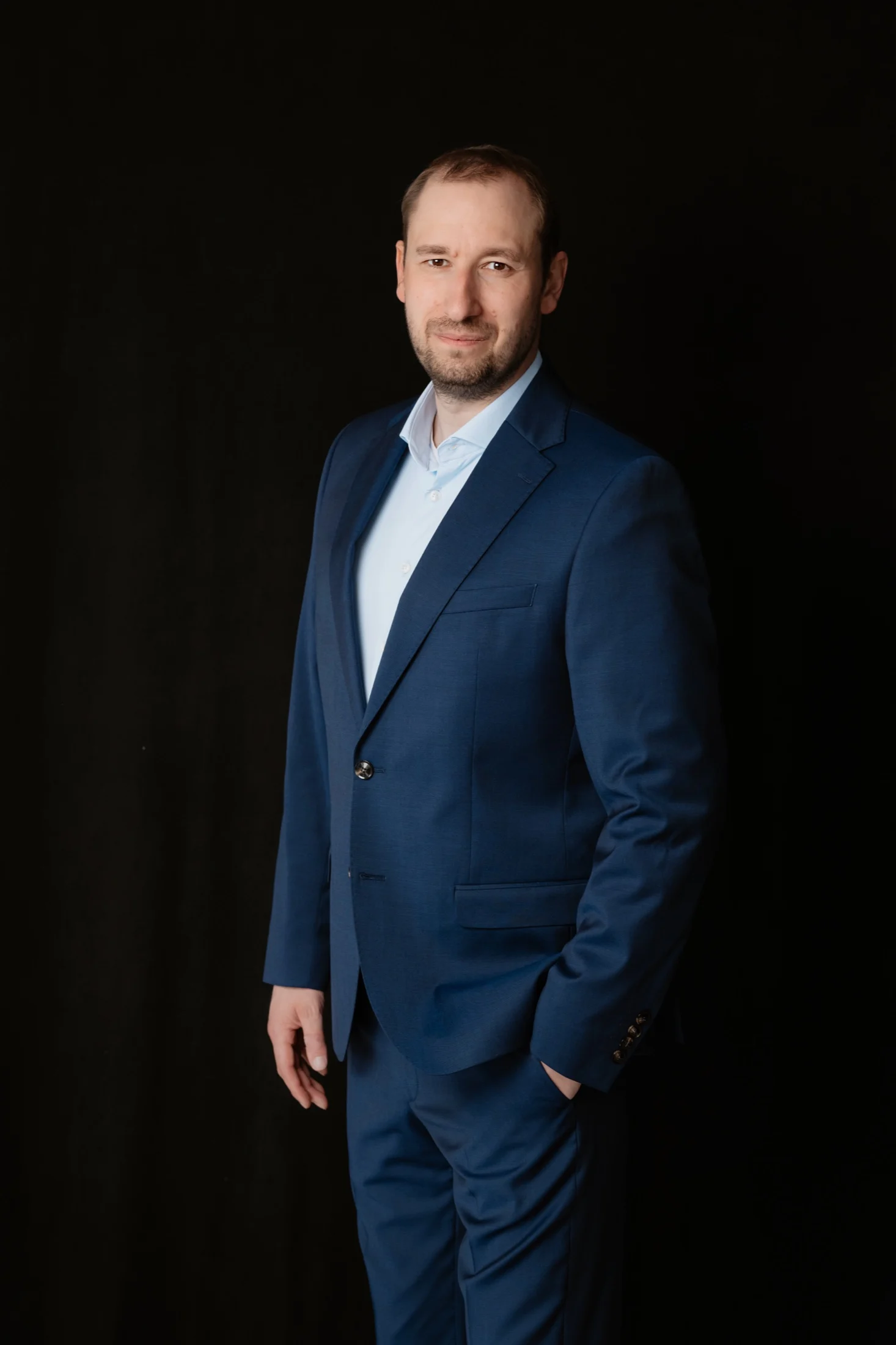 Martin Berdel standing against a dark background